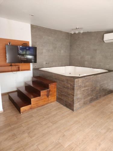グアダラハラにあるMOTEL PREMIERのバスルーム(バスタブ付)、壁にテレビが備わります。