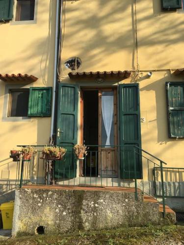 a house with a green door and a balcony at Welcome in Toscana in Polcanto