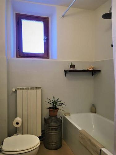 a bathroom with a toilet and a tub and a window at Welcome in Toscana in Polcanto