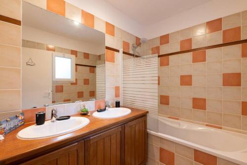 une salle de bain avec deux lavabos et une baignoire dans l'établissement Villa calme du golf avec piscine proche du lac, à Biscarrosse