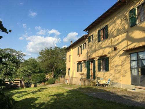 un gran edificio amarillo con un patio de césped al lado en Welcome in Toscana, en Polcanto