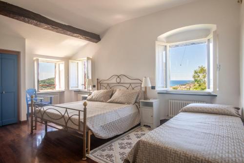 ein Schlafzimmer mit zwei Betten und einem Fenster in der Unterkunft 164- Villa della Marchesa - Giardino e Piscina a pochi minuti dal centro di Sestri Levante in Santo Stefano del Ponte