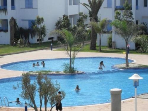 un gruppo di persone che nuotano in piscina di Bel appartement à sania plage vue sur mer a M'diq