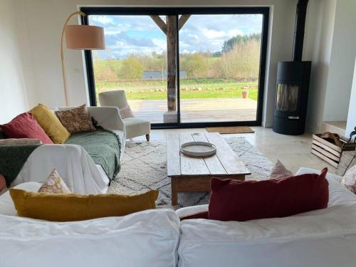 un salon avec deux canapés et une cheminée dans l'établissement La Grange du Bois Germain, à Saint-Antonin-de-Sommaire