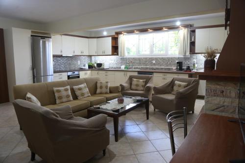 uma sala de estar com sofás e uma mesa na cozinha em George’s House em Kími