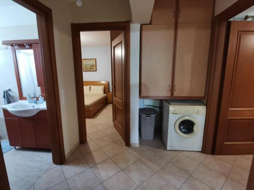 uma casa de banho com um lavatório e uma máquina de lavar roupa em George’s House em Kími