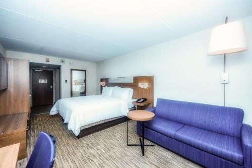 une chambre d'hôtel avec un lit et un canapé dans l'établissement Holiday Inn Express Boston - Saugus, an IHG hotel, à Saugus