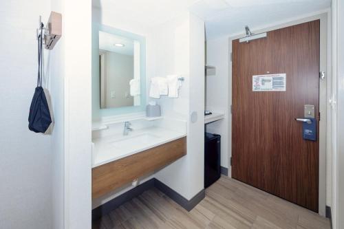 a bathroom with a sink and a wooden door at Holiday Inn Express Boston - Saugus, an IHG hotel in Saugus
