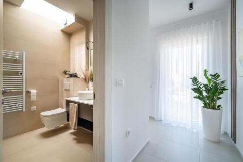 łazienka z umywalką, toaletą i rośliną w obiekcie Villa Kurnatari w mieście Jezera