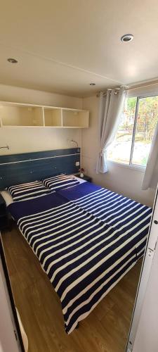 duże łóżko w pokoju z oknem w obiekcie Mobile Home Shelbox w Biogradzie na Moru