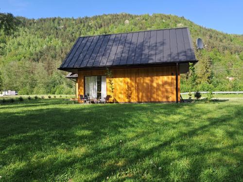dom z dachem słonecznym na trawniku w obiekcie Mała Gorczańska Chatka w mieście Ochotnica Dolna