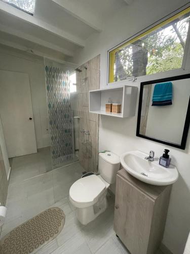 a bathroom with a white toilet and a sink at Romántico refugio en la montaña in Copacabana