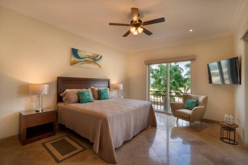 um quarto com uma cama e uma ventoinha de tecto em Condo Maravilla - New luxurious condo 300mt from the beach em Cabo San Lucas