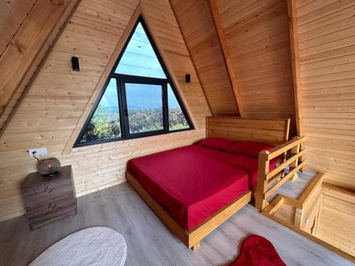 a bedroom in a wooden cabin with a large window at El-Ya Bungalov ve pansiyon in Dalaman