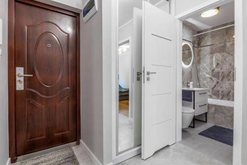 een badkamer met een houten deur en een toilet bij Warsaw Center ClassicRooms in Warschau