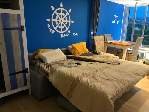 ein Schlafzimmer mit einem Bett mit einem Rad an der Wand in der Unterkunft Athéna OHANA, les pieds dans l'eau in Bandol