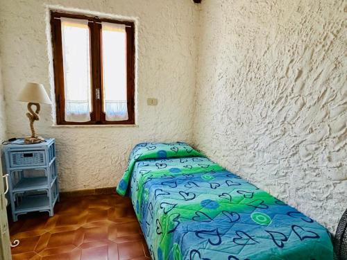 a bedroom with a bed and a table and a window at Rena Majore in vacanza in Rena Majore