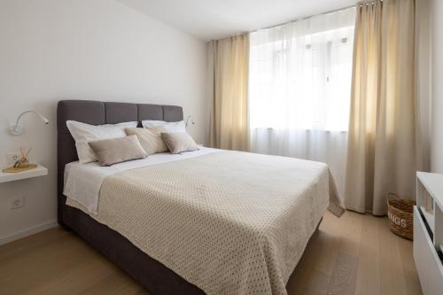 杜基拉特的住宿－Apartment Nova 4*，白色卧室设有一张大床和窗户