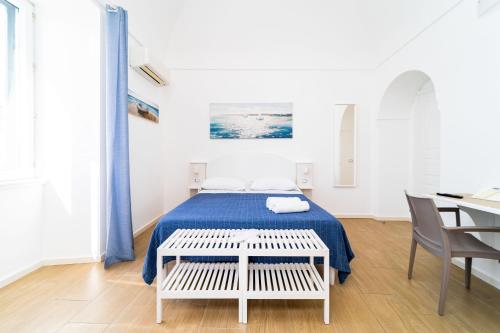 a white room with a bed and a table and chairs at FRENNESIA Amalfi Coast in Atrani