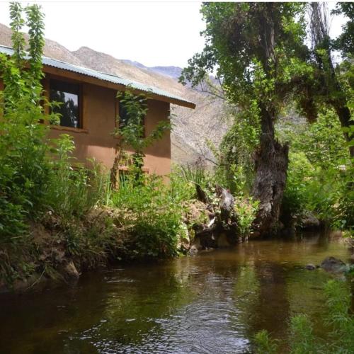 a house next to a river next to a building at CASAS AMANCAY - Alcohuaz in Alcoguaz