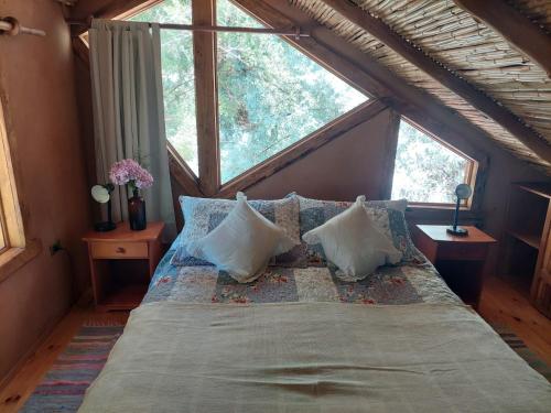 ein großes Bett in einem Zimmer mit einem großen Fenster in der Unterkunft CASAS AMANCAY - Alcohuaz in Alcoguaz