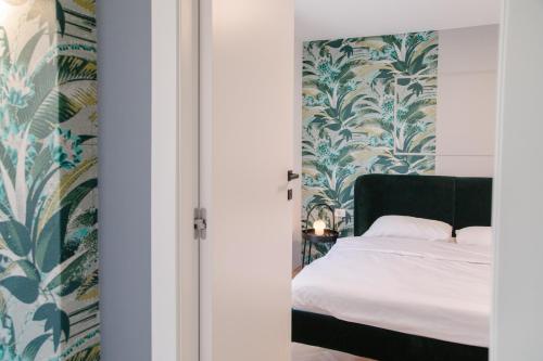 a bedroom with a bed with blue and green wallpaper at Apartments Toni in Split
