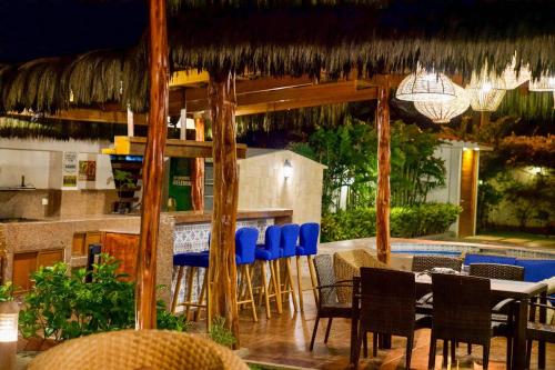 um restaurante com mesa e cadeiras e um bar em CASA PUNTA CARNERO em Presidente Tamayo