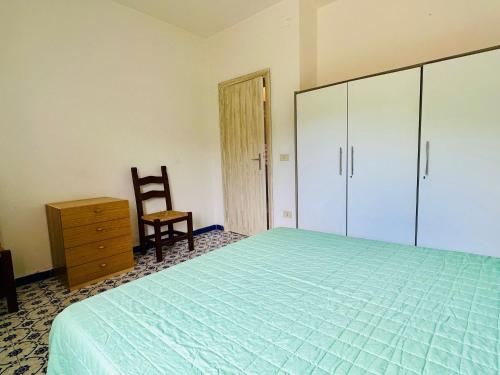 a bedroom with a bed and a chair and a dresser at Rena Majore in vacanza in Rena Majore
