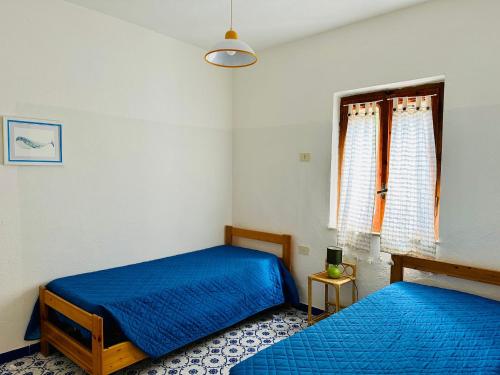 a bedroom with two beds and a window at Rena Majore in vacanza in Rena Majore