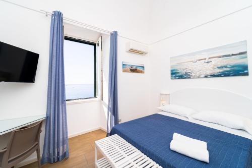 a bedroom with a bed and a tv and a window at FRENNESIA Amalfi Coast in Atrani