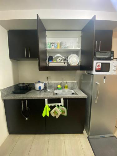 a small kitchen with a sink and a refrigerator at Your Crib - kasara -19 D tower 1 in Manila