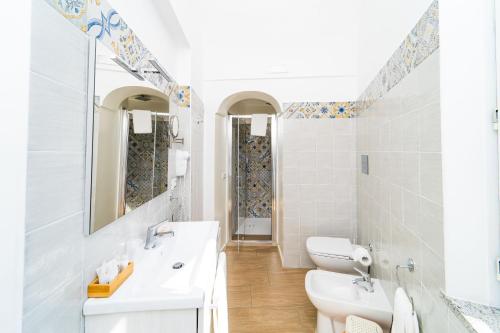 a white bathroom with a sink and a toilet at FRENNESIA Amalfi Coast in Atrani