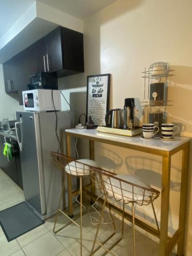 a small kitchen with a table and a refrigerator at Your Crib - kasara -19 D tower 1 in Manila