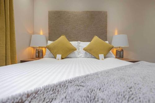 a bedroom with a large white bed with two lamps at Craignish Apartments in Falkirk
