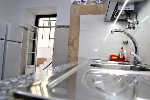eine Küche mit einer Spüle und einer Arbeitsplatte in der Unterkunft Family Bedroom in Lissabon