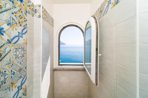 uma janela arqueada numa casa de banho com vista para o oceano em FRENNESIA Amalfi Coast em Atrani