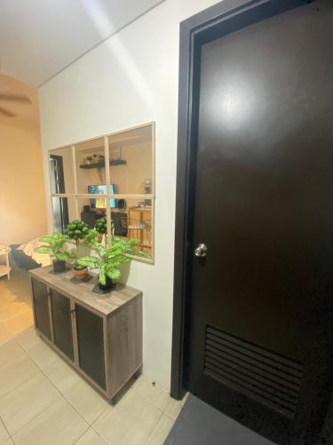 a black door in a room with potted plants at Your Crib - kasara -19 D tower 1 in Manila