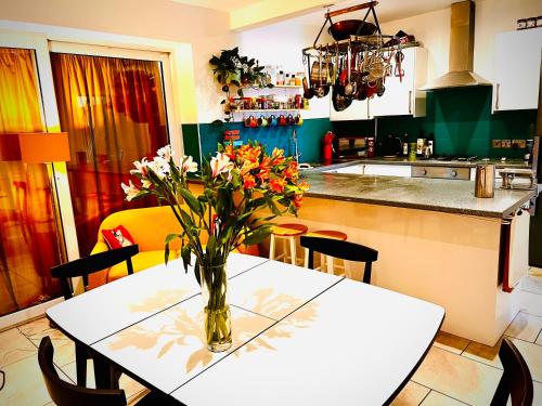 una cocina con una mesa con un jarrón de flores. en Liverpool - Cosy Jazzy Beach Home! en Waterloo