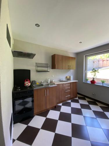 a kitchen with a black and white checkered floor at Agroturystyka ‚U Misia’ in Krzywopłoty