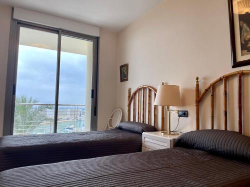 a bedroom with two beds and a window with a view at Puerto - Somhome in Benicarló