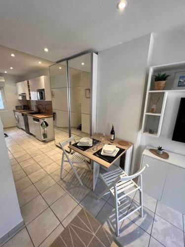 une cuisine avec une table et des chaises dans une pièce dans l'établissement Appartement climatisé en bord de mer, à La Ciotat