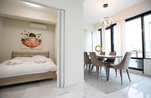 a bedroom with a bed and a dining room with a table at MELMA PROPERTIES - ARIA-Piraeus Central Penthouse in Piraeus