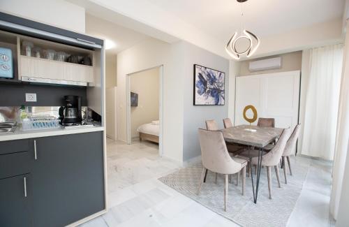 a kitchen and dining room with a table and chairs at MELMA PROPERTIES - ARIA-Piraeus Central Penthouse in Piraeus