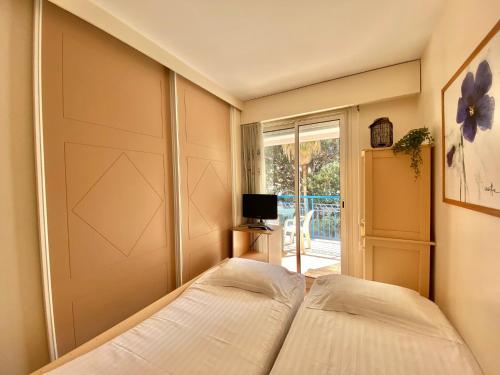 - une chambre avec un lit et une porte coulissante dans l'établissement Joli 2 pièces vue jardin 50m plage Parking Clim, à Menton
