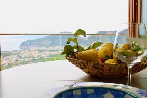 a basket of lemons on a table with a glass at Fountain House Sorrento in Sant'Agnello