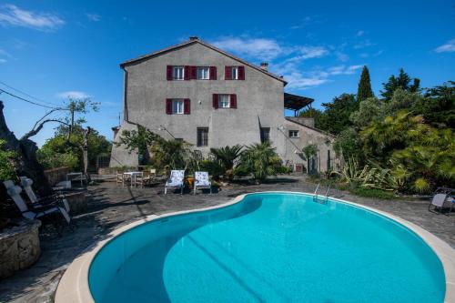 ein altes Haus mit einem Swimmingpool vor einem Gebäude in der Unterkunft 164- Villa della Marchesa - Giardino e Piscina a pochi minuti dal centro di Sestri Levante in Santo Stefano del Ponte