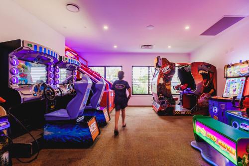 a person walking through a room with arcade games at BIG4 Sandstone Point Holiday Resort Bribie Island in Bongaree