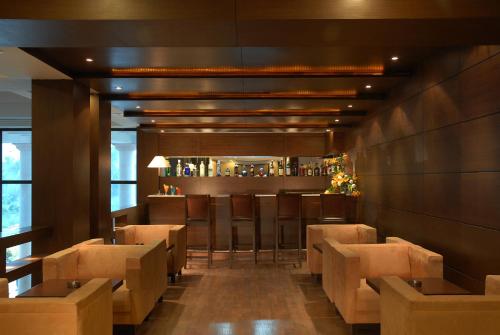 a restaurant with brown chairs and a bar at Fortune Park Panchwati, Kolkata - Member ITC Hotels' Group in Kolkata