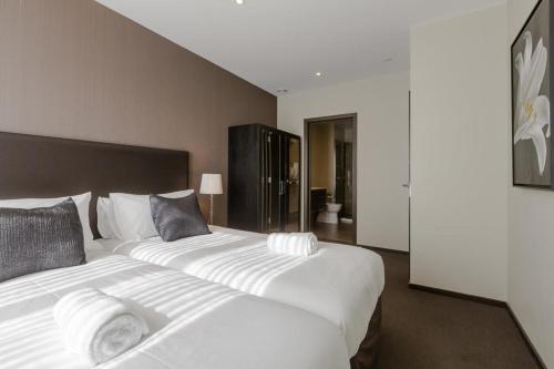 a bedroom with two large white beds in it at Queenstown Village Apartments in Queenstown