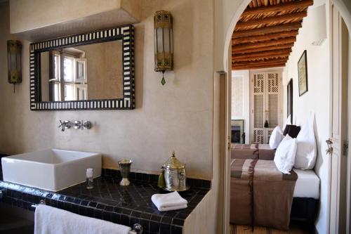 La salle de bains est pourvue d'un lavabo, d'un miroir et d'un lit. dans l'établissement Riad Al Massarah, à Marrakech